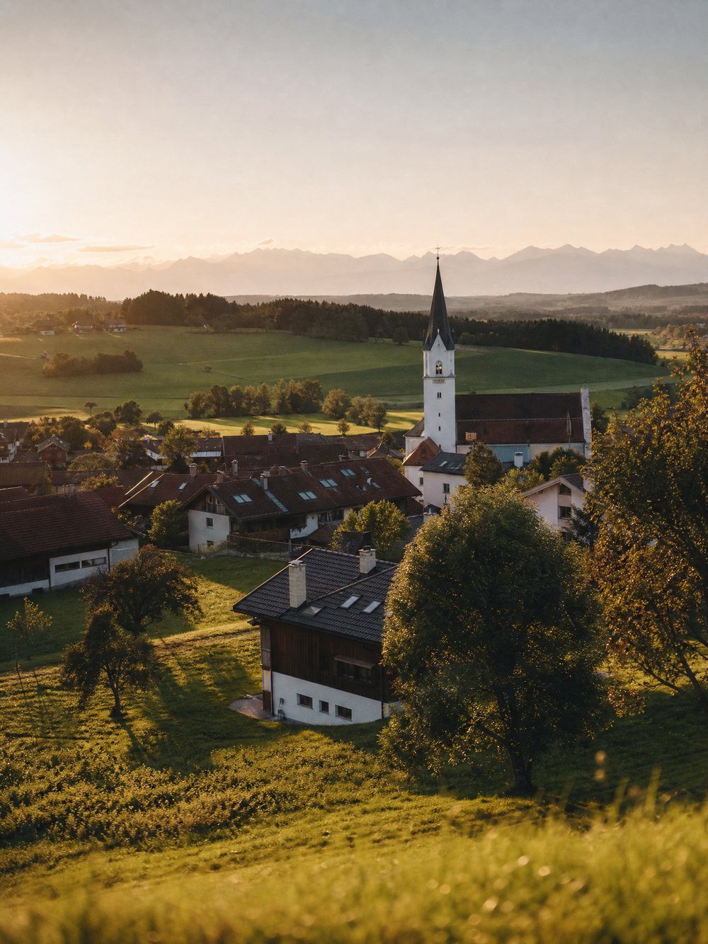 Oberbayerische Ortschaft mit Kirchturm im Abendlicht – das Einzugsgebiet der Brandhuber GmbH